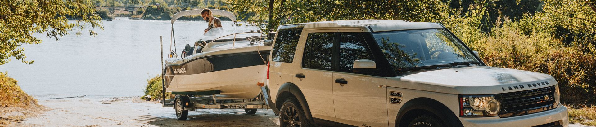A four-wheel drive towing a boat trailer down to the water's edge