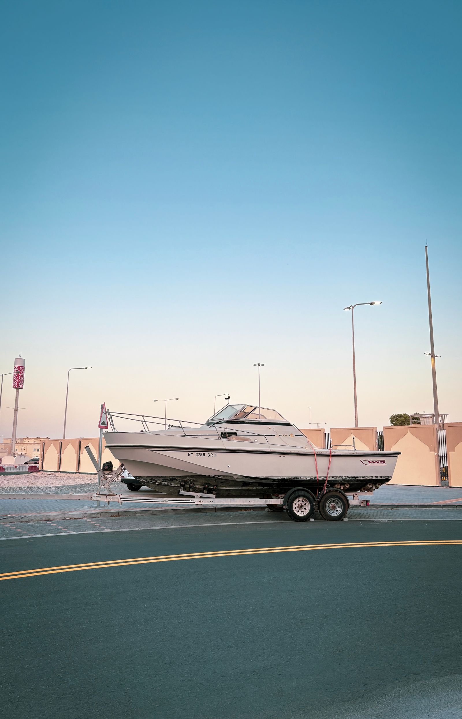 A boat on a tandem-axle trailer, showing the hull, frame and both wheel hubs