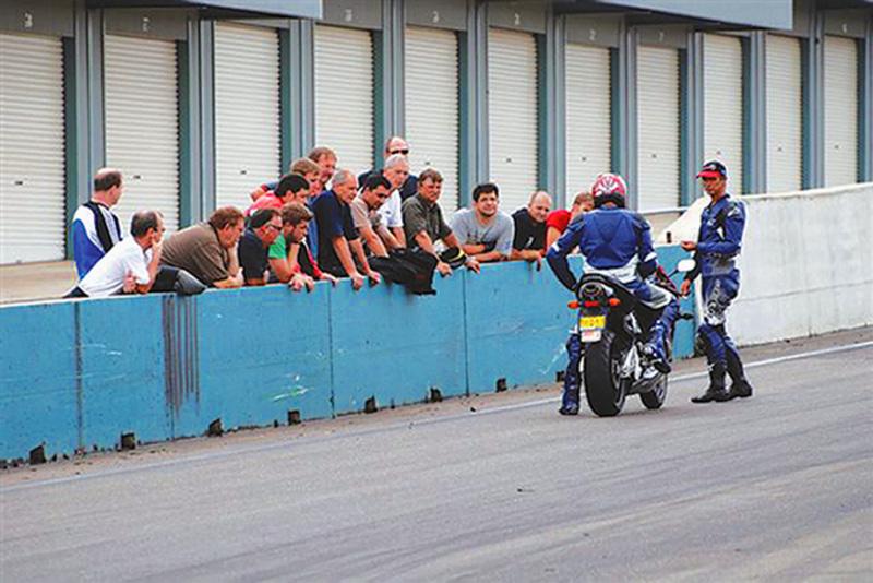Stay Upright Instructor demonstrating a technique in front of the pitlane wall